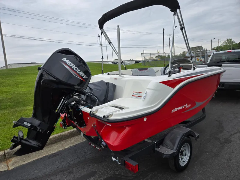 Slide: The Image of 2022 Bayliner Element M15 boat with Mercury engine, red and white design, on a trailer. - 3