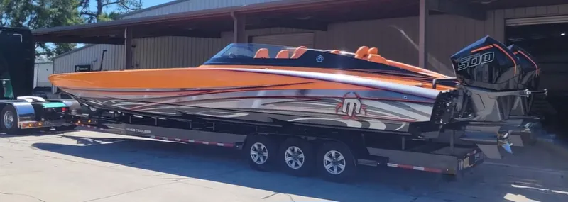 Slide: The Image of 2024 Mystic Powerboats C4000 in vibrant orange and silver, displayed on a trailer. - 10
