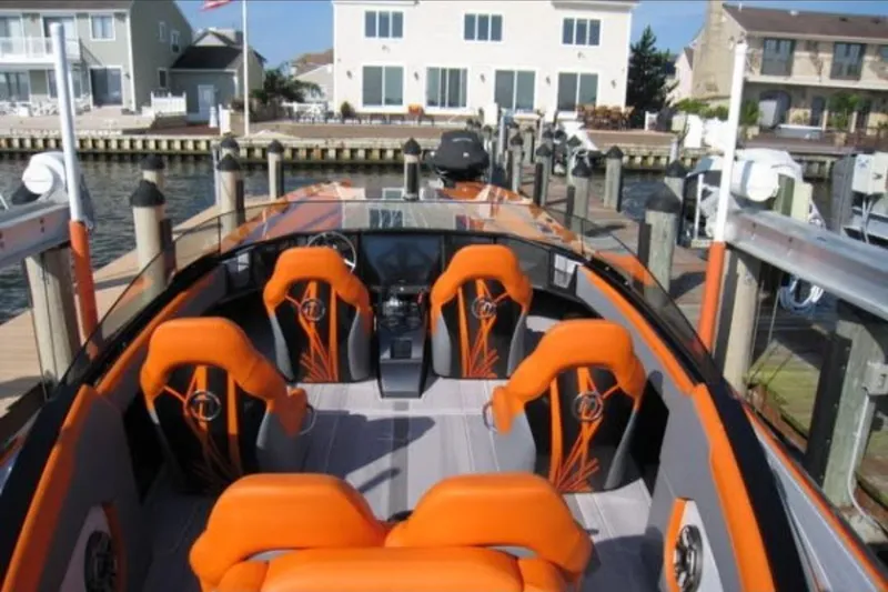 Slide: The Image of 2024 Mystic Powerboats C4000 with vibrant orange seating docked at a marina. - 15