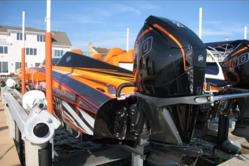 Slide: The Image of 2024 Mystic Powerboats C4000 with vibrant orange and black design, docked at a marina. - 17