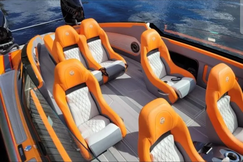 Slide: The Image of 2024 Mystic Powerboats C4000 interior with orange and white luxury seating. - 18