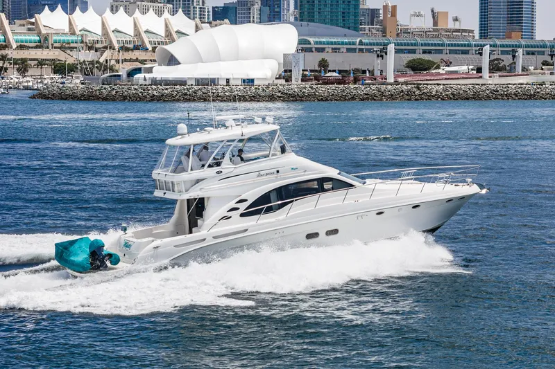 Slide: The Image of 2008 Sea Ray 58 Sedan Bridge yacht cruising in a vibrant harbor setting. - 4