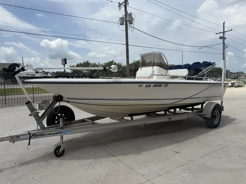 Slide: The Image of 2001 Key West 196 Bay Reef boat on trailer, parked outdoors under cloudy sky. - 14