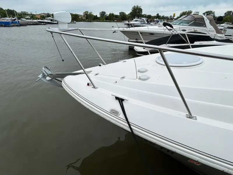 Slide: The Image of 2006 Cruisers Yachts 300 Express docked at a marina, featuring sleek white design. - 13