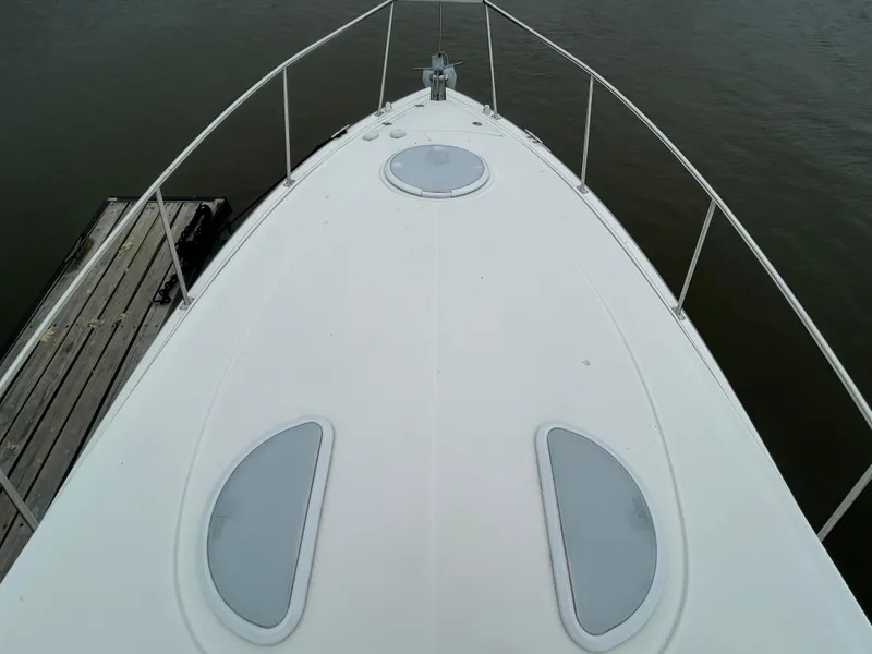 Slide: The Image of 2006 Cruisers Yachts 300 Express boat deck, docked on calm water. - 14