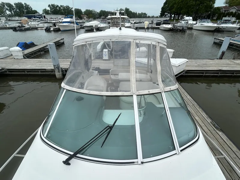 Slide: The Image of 2006 Cruisers Yachts 300 Express docked at a marina, featuring a clear windshield. - 17