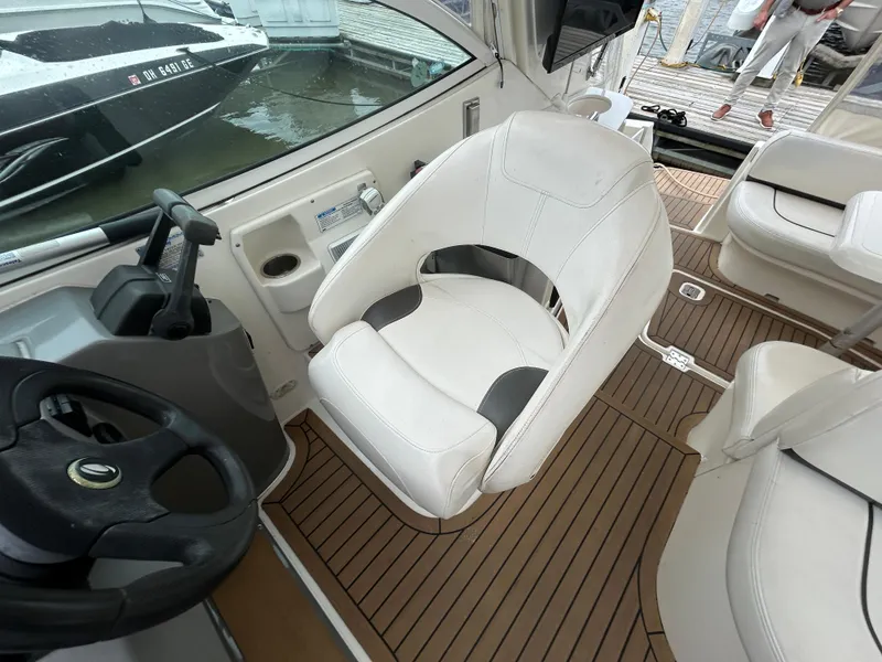 Slide: The Image of 2006 Cruisers Yachts 300 Express helm with white captain's chair and wood flooring. - 39