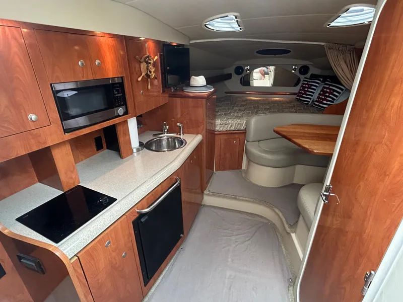 Slide: The Image of 2006 Cruisers Yachts 300 Express interior with kitchen, seating, and sleeping area. - 41