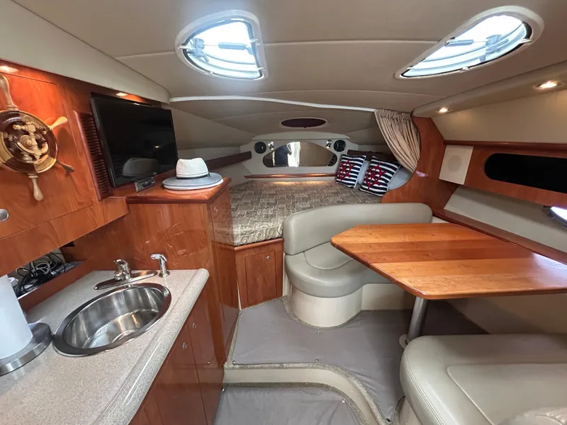 Slide: The Image of 2006 Cruisers Yachts 300 Express cabin interior with kitchenette, seating, and bed. - 43