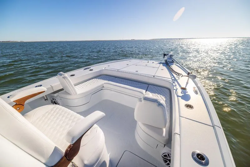 Slide: The Image of 2024 Freeman 28 boat on open water, featuring sleek white seating and sunny ocean view. - 3