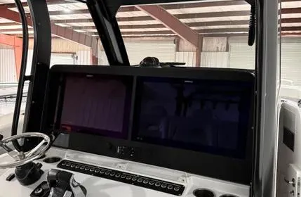 Slide: The Image of 2022 Freeman 43 boat dashboard with dual screens and steering wheel in a warehouse setting. - 6
