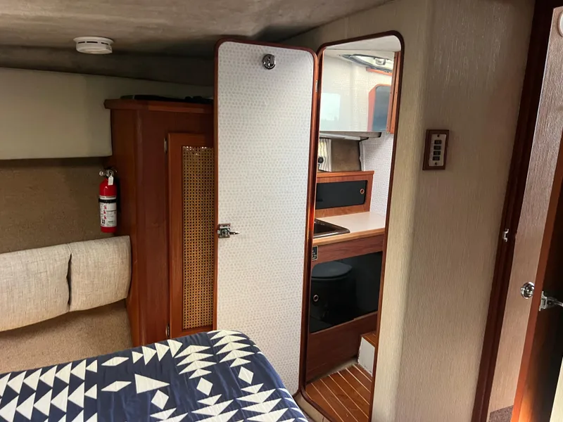 Slide: The Image of 1986 Bayliner 3870 Motoryacht cabin interior with TV, bed, and wooden cabinetry. - 23