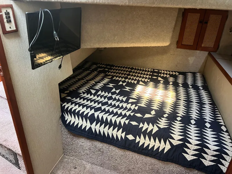 Slide: The Image of 1986 Bayliner 3870 Motoryacht interior with bed, kitchenette, and wooden cabinetry. - 24