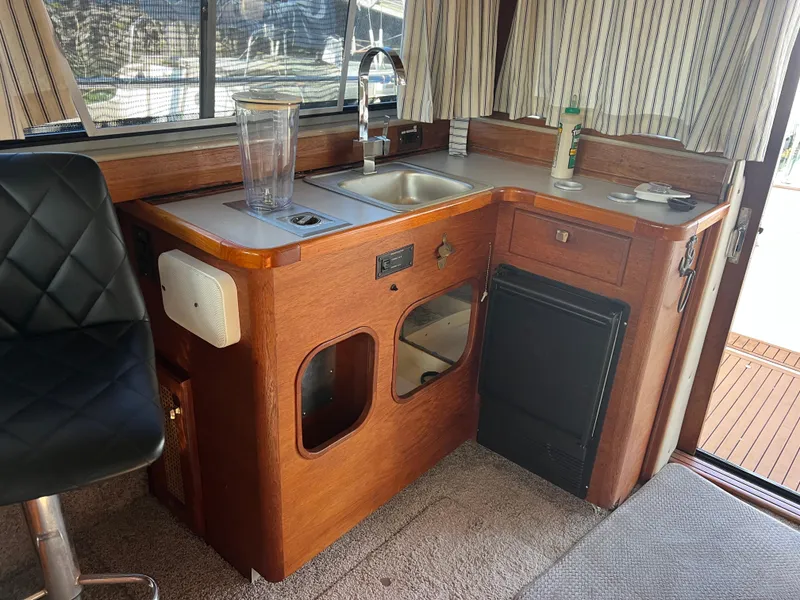Slide: The Image of Interior of 1986 Bayliner 3870 Motoryacht with cushioned seating and wooden table. - 26