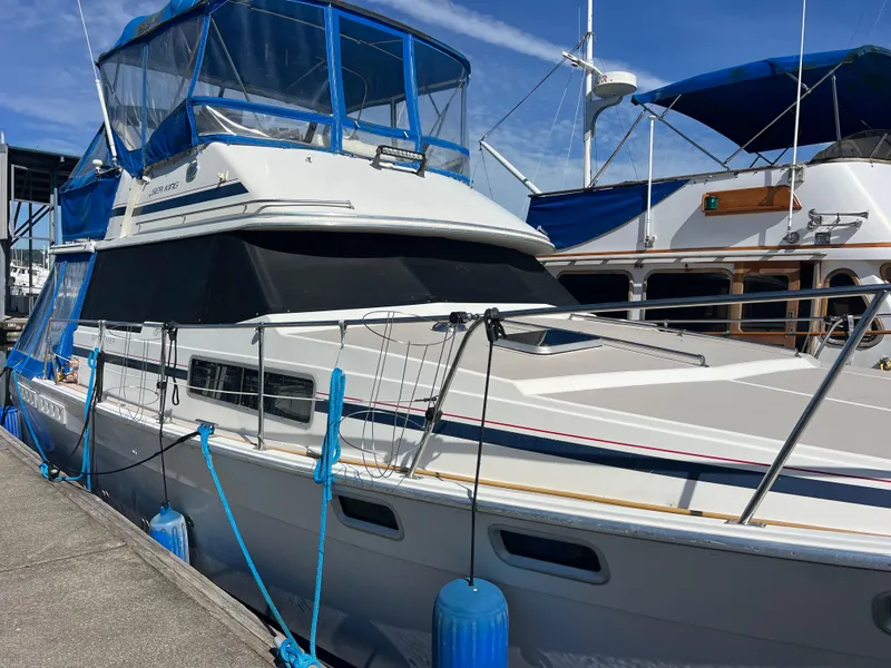 Slide: The Image of 1986 Bayliner 3870 Motoryacht docked at marina under clear blue sky. - 4