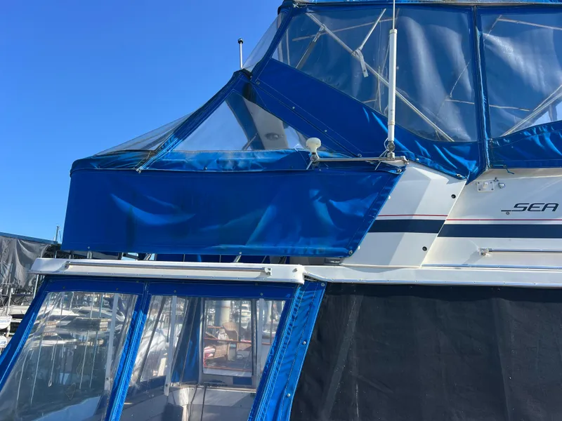 Slide: The Image of 1986 Bayliner 3870 Motoryacht with blue canopy docked at marina. - 42