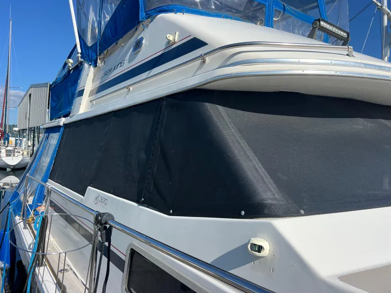 Slide: The Image of 1986 Bayliner 3870 Motoryacht docked at marina, showcasing deck and railing. - 44