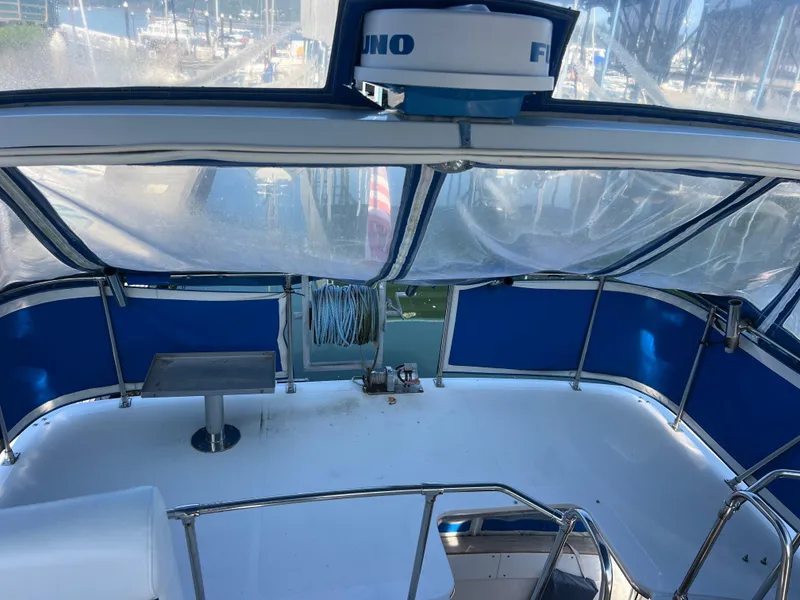 Slide: The Image of 1986 Bayliner 3870 Motoryacht with blue canopy, docked at marina under clear sky. - 45