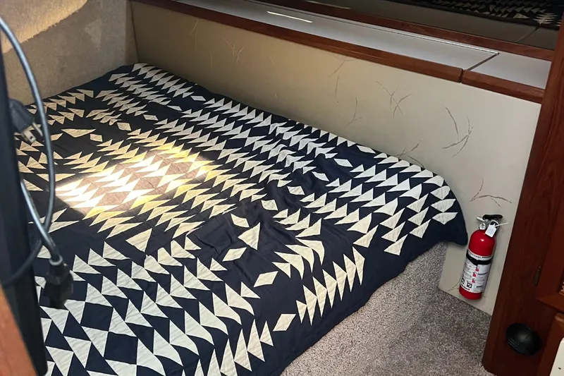 Slide: The Image of 1986 Bayliner 3870 Motoryacht interior showing bathroom and bedroom with patterned bedding. - 49