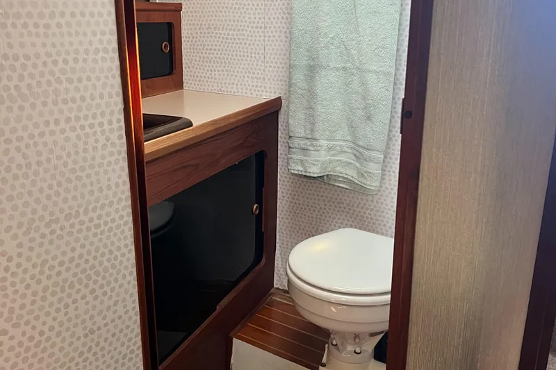 Slide: The Image of Cozy cabin interior of 1986 Bayliner 3870 Motoryacht with geometric-patterned bedding and fire extinguisher. - 50