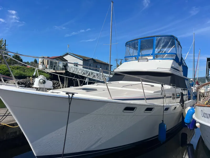 Slide: The Image of 1986 Bayliner 3870 Motoryacht docked with blue canopy and fenders. - 6
