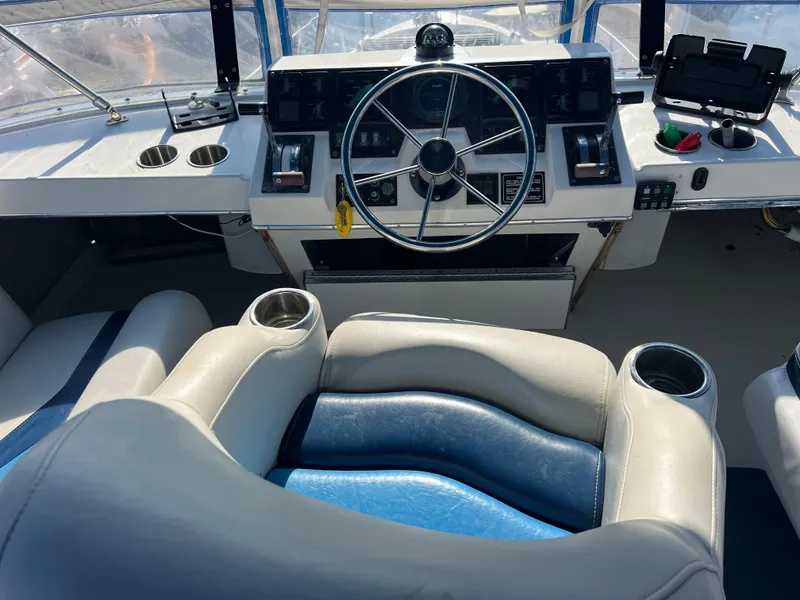 Slide: The Image of 1986 Bayliner 3870 Motoryacht bow with anchor and winch, docked near a wooden pier. - 7