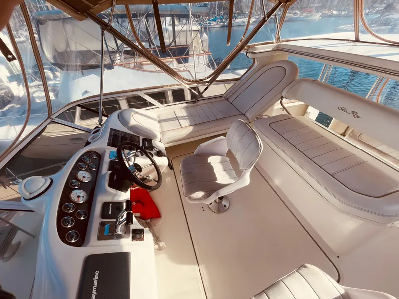 Slide: The Image of 1998 Sea Ray 370 Aft Cabin helm with marina view, featuring dual captain chairs and navigation equipment. - 10