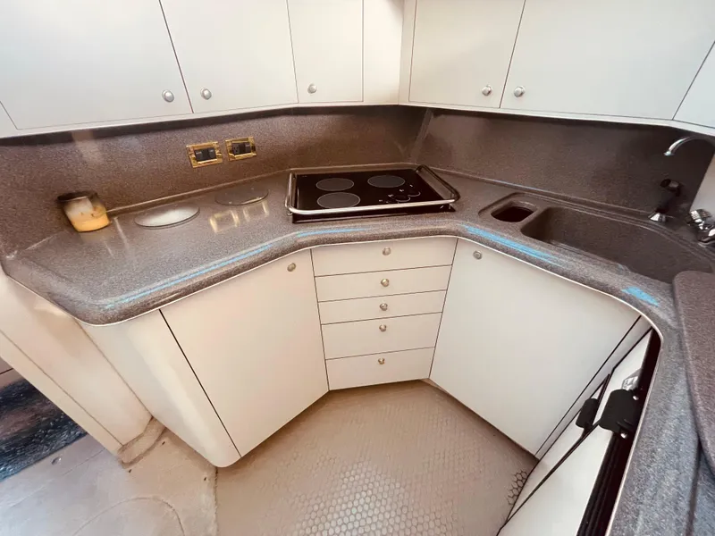 Slide: The Image of 1998 Sea Ray 370 Aft Cabin helm with marina view, featuring navigation equipment and seating. - 29