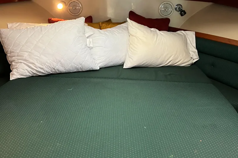 Slide: The Image of Cozy cabin interior of 2004 Albin 35 Tournament Express with pillows and green bedding. - 24