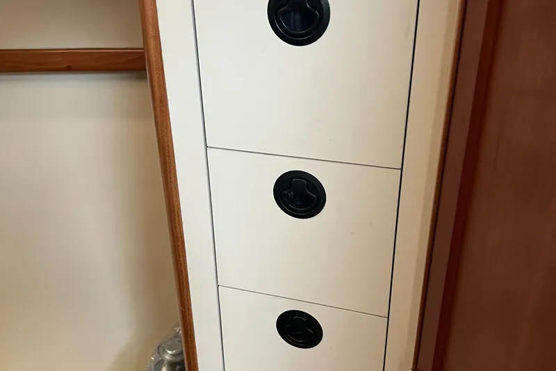 Slide: The Image of Cabinet drawers with black handles inside a 2004 Albin 35 Tournament Express boat. - 25