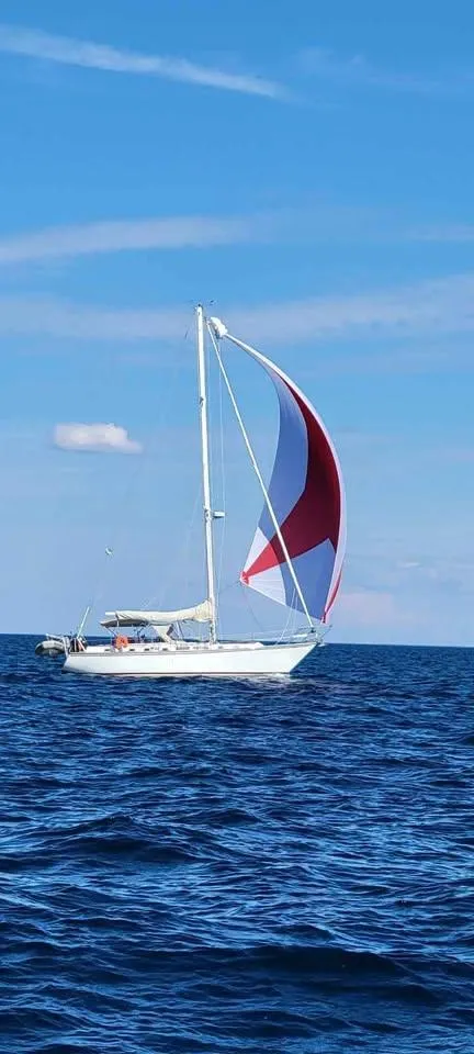 The Image of Sailboat Endeavour 42 CC, 1985 model, with red and white sail on open sea. - 0