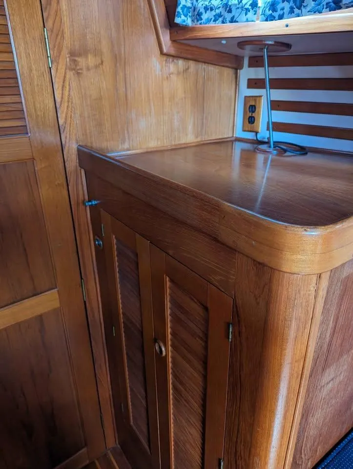 Slide: The Image of Wooden interior of 1985 Endeavour 42 CC sailboat, featuring cabinets and a small desk area. - 7