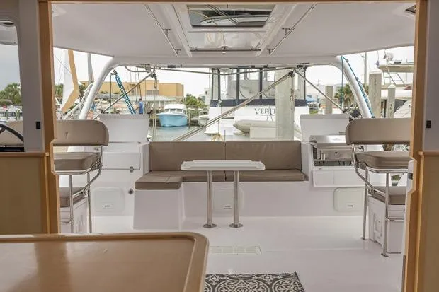 Slide: The Image of 2019 Seawind 1260 catamaran interior with seating and table, docked at marina. - 10
