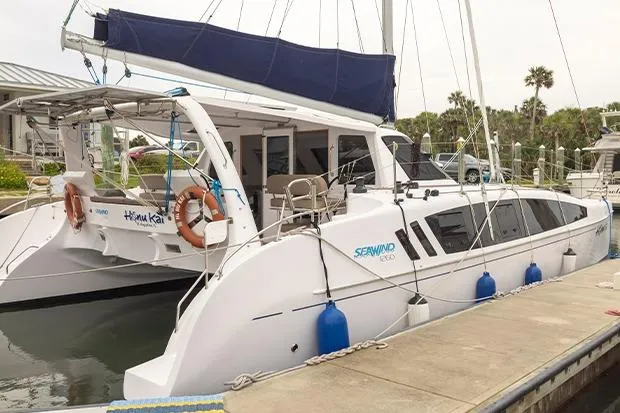Slide: The Image of 2019 Seawind 1260 catamaran docked, featuring sleek design and spacious deck. - 2