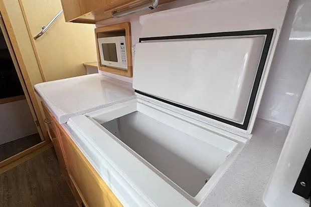 Slide: The Image of 2019 Seawind 1260 yacht kitchen with open fridge and microwave. - 20