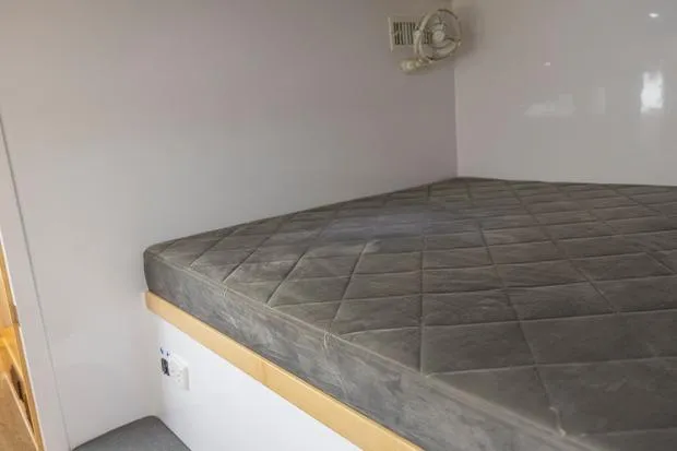 Slide: The Image of Interior cabin of 2019 Seawind 1260 catamaran with a comfortable bed and fan. - 22