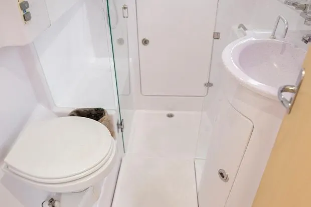Slide: The Image of 2019 Seawind 1260 yacht bathroom with toilet, sink, and shower in compact layout. - 26
