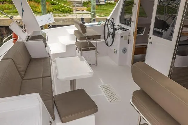 Slide: The Image of 2019 Seawind 1260 catamaran cockpit with seating, steering wheel, and tables. - 7
