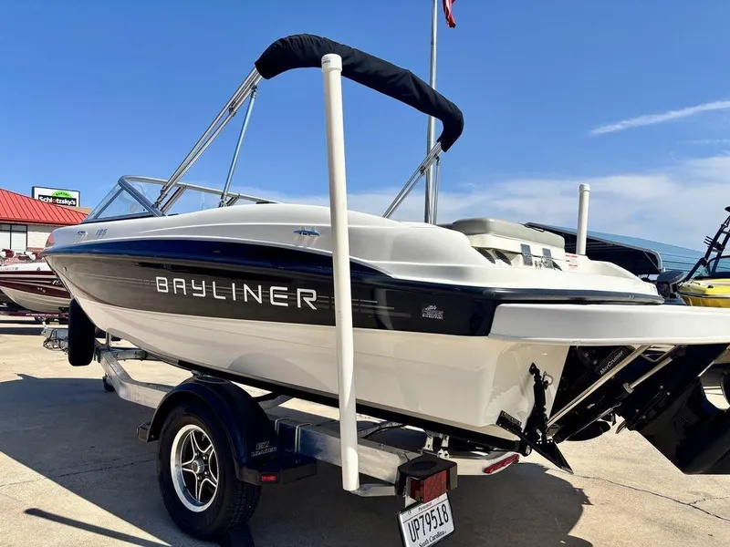 Slide: The Image of 2012 Bayliner 185 Bowrider boat on trailer, displayed outdoors under clear blue sky. - 2