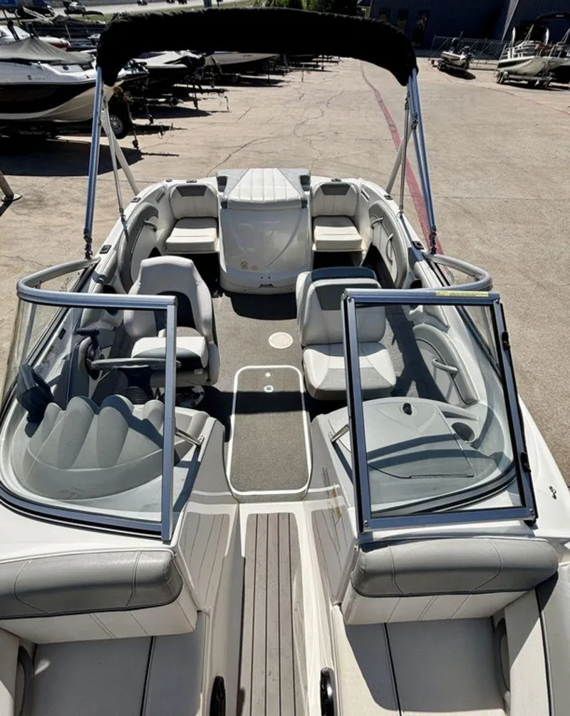 Slide: The Image of 2012 Bayliner 185 Bowrider boat with open seating and canopy, parked on concrete. - 3