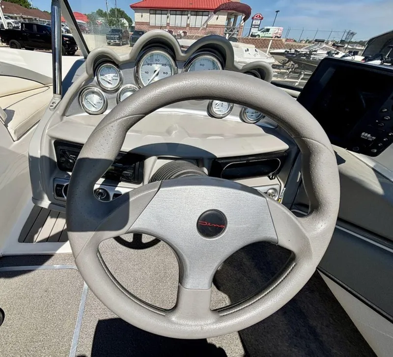 Slide: The Image of Steering wheel and dashboard of 2012 Bayliner 185 Bowrider boat, featuring multiple gauges. - 4