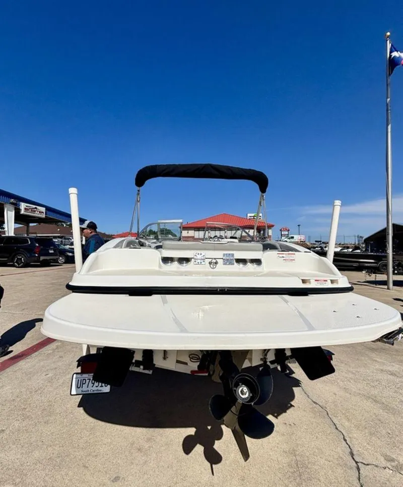 Slide: The Image of 2012 Bayliner 185 Bowrider boat, rear view, parked outdoors under clear blue sky. - 7