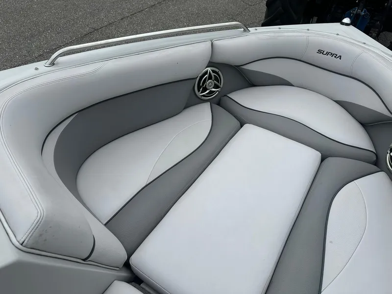 Slide: The Image of 2009 Supra Launch 22 SSV boat interior with gray and white cushioned seating. - 12