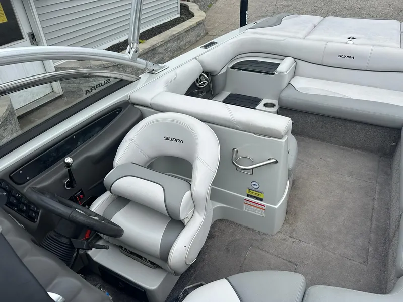 Slide: The Image of 2009 Supra Launch 22 SSV boat interior with gray seating and steering wheel. - 15
