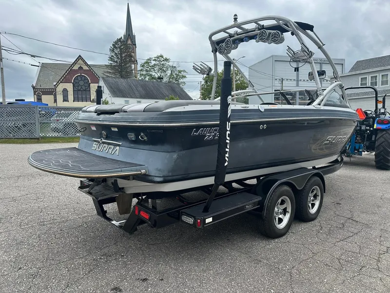 Slide: The Image of 2009 Supra Launch 22 SSV boat on trailer, parked outdoors near buildings and a church. - 4