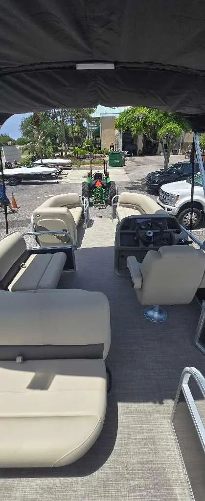 Slide: The Image of 2025 Sun Tracker Party Barge 18 DLX interior with seating and steering console. - 2