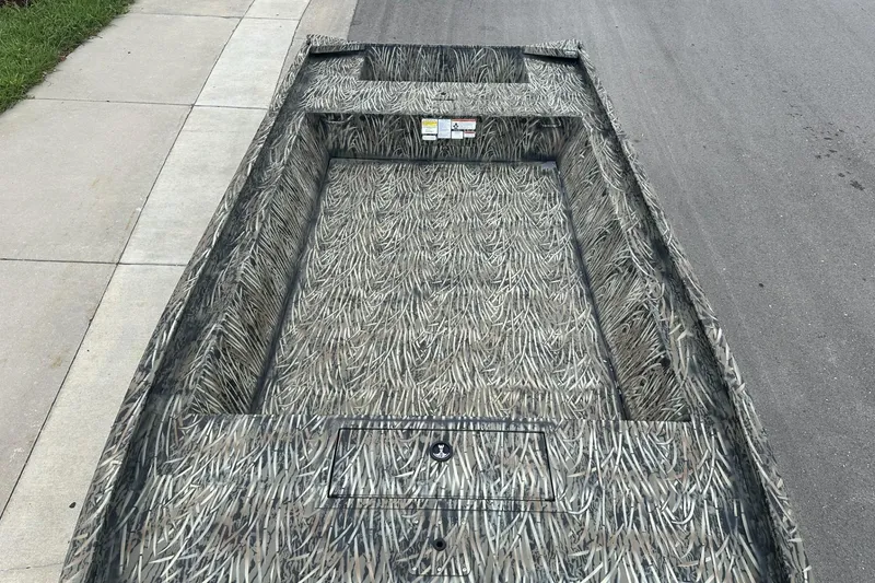 Slide: The Image of 2025 Tracker Grizzly 1860 Utility boat with camouflage pattern on a street. - 6