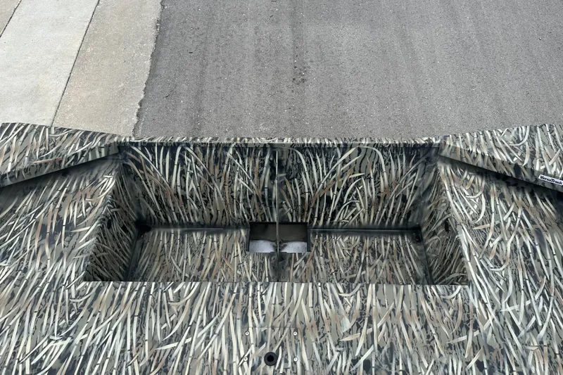 Slide: The Image of 2025 Tracker Grizzly 1860 Utility boat with camouflage pattern on pavement background. - 8