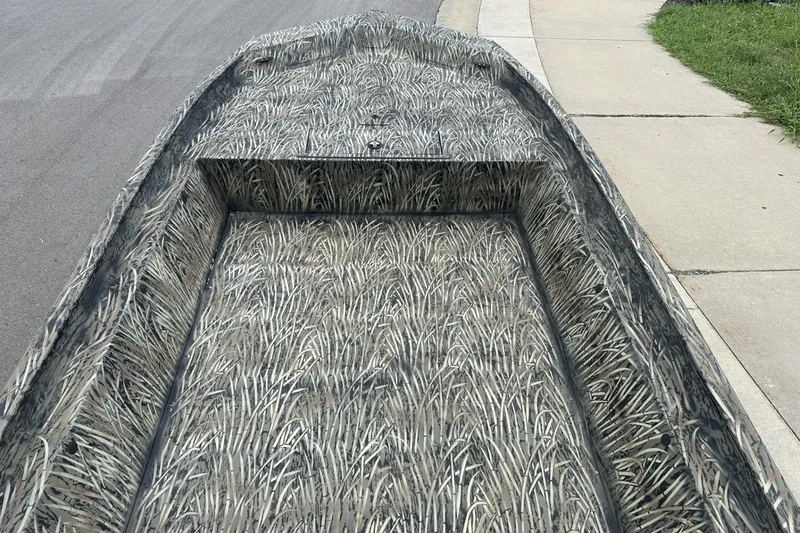 Slide: The Image of 2025 Tracker Grizzly 1860 Utility boat with camouflage pattern on a street. - 10