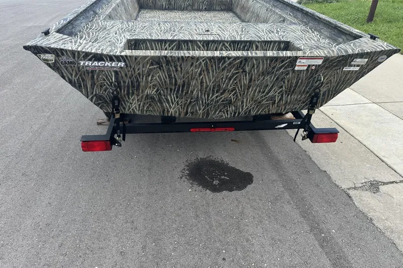Slide: The Image of 2025 Tracker Grizzly 1860 Utility boat with camo design on a trailer. - 2